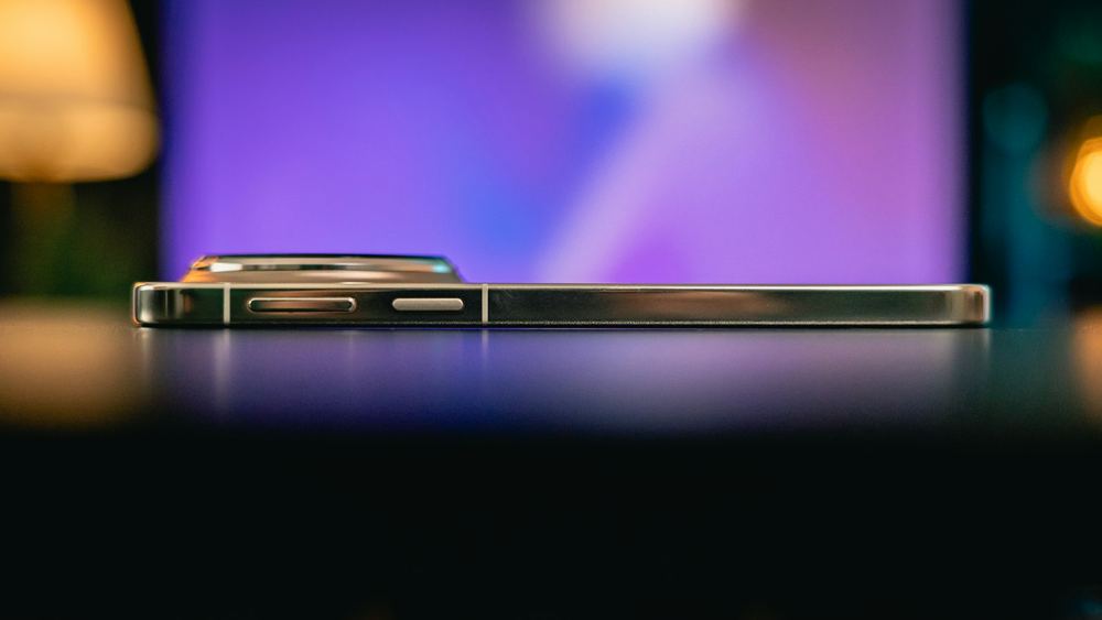 A mobile device lying on a dark desk in soft purple light